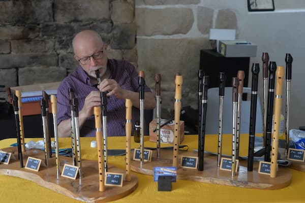 Artisan fabriquant des flûtes traditionnelles en bois au festival musique irlandaise en France.