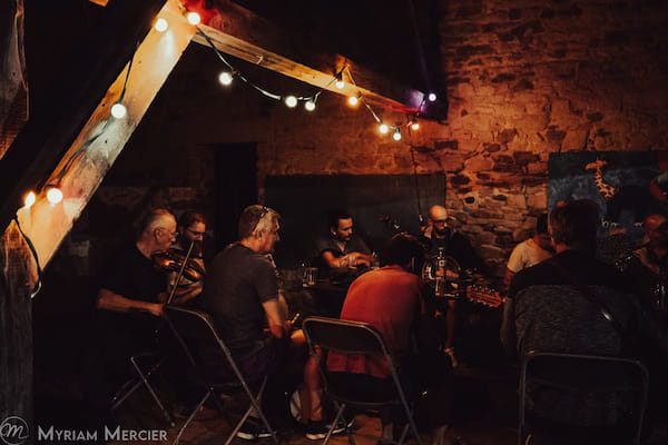 Session de musique traditionnelle en soirée, éclairage coloré.