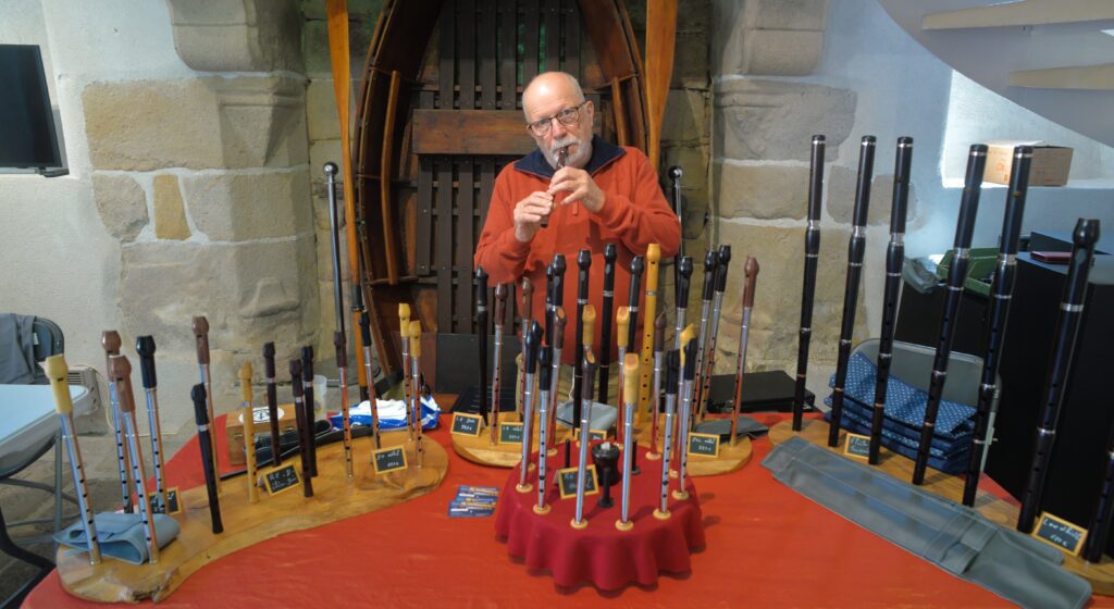 Homme présentant une collection de flûtes à bec