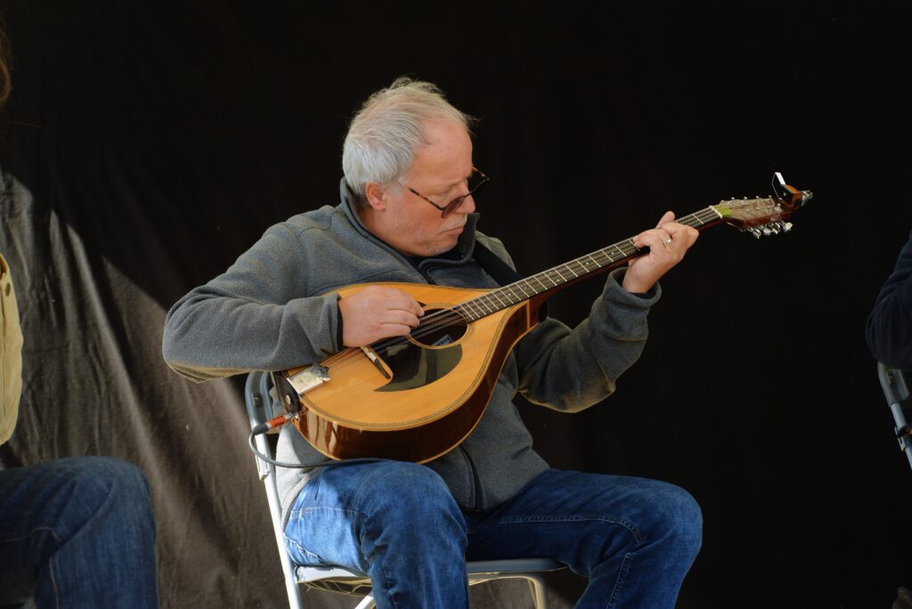 Homme âgé jouant de la mandoline assis