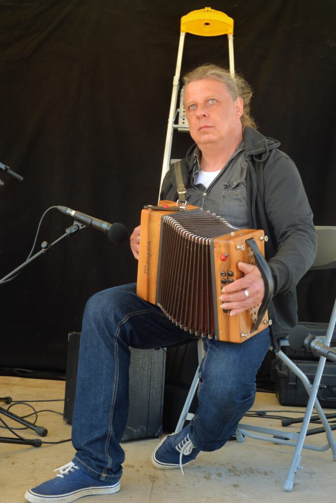 Homme jouant de l'accordéon assis sur chaise