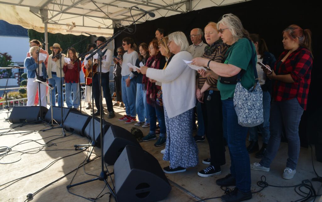 Chœur d'adultes chantant en extérieur sur scène