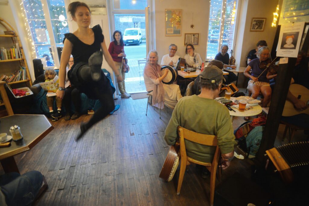 Femme danse dans café animé avec musiciens et spectateurs