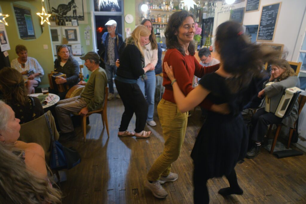 Personnes dansant joyeusement dans un café animé