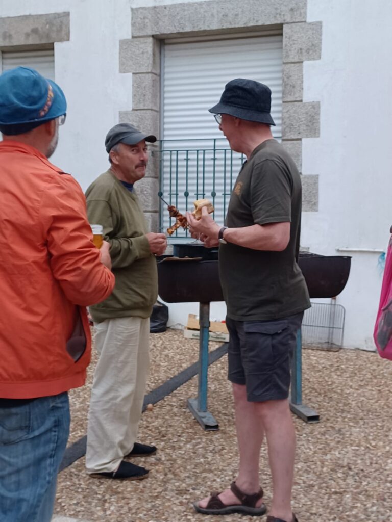 Hommes discutant près d'un barbecue extérieur