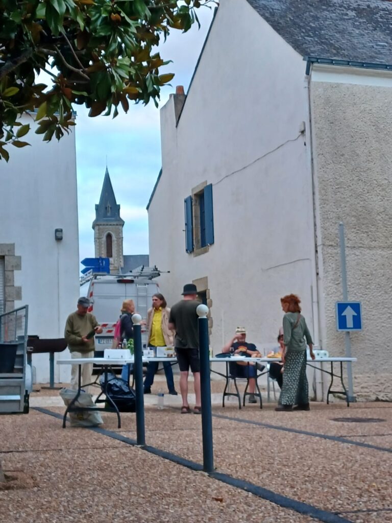 Personnes dînant dans une cour, village européen.