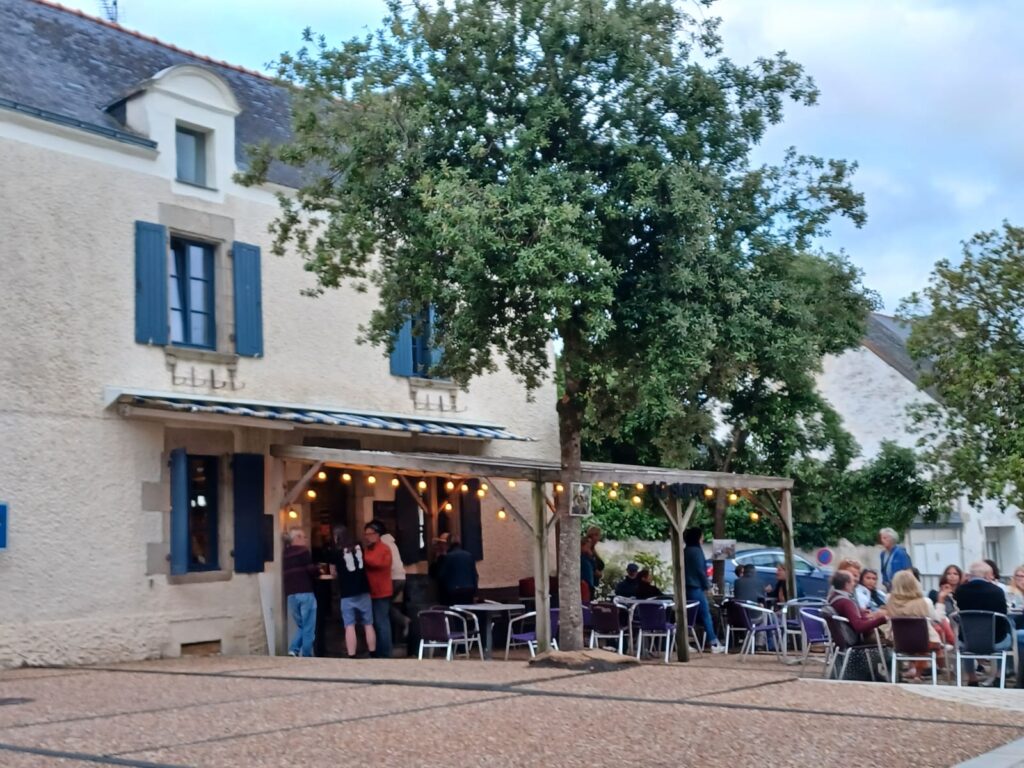 Restaurant extérieur animé en soirée avec éclairage