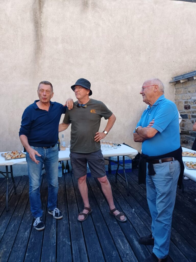 Trois hommes discutent lors d'une réception en extérieur