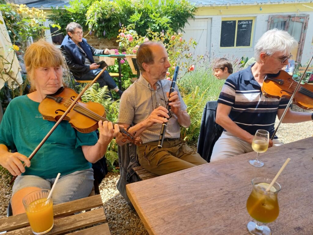 Trois personnes jouant du violon en jardin ensoleillé