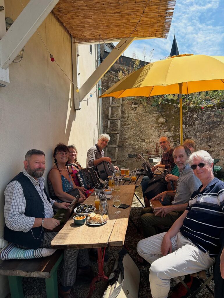 Groupe d'amis déjeunant dehors avec accordéoniste