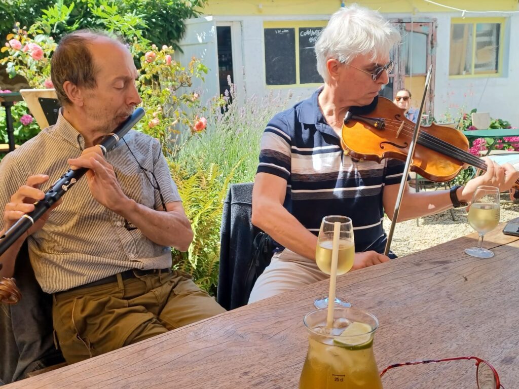 Deux hommes jouent de la musique, boissons sur table