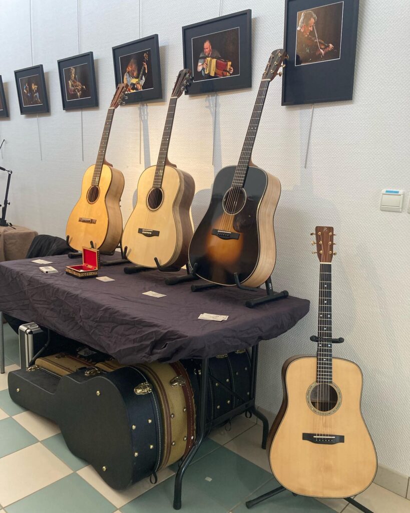 Guitares et valises exposées avec photos de musiciens